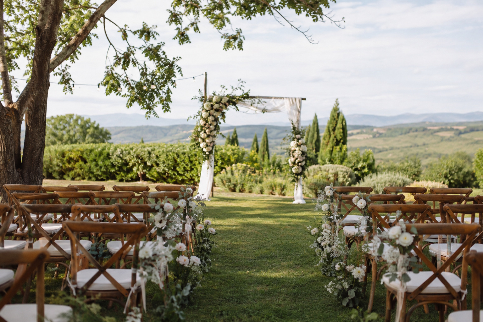 Elegante Outdoor-Hochzeit unter einem hellen Hochzeitszelt mit festlich gedeckten Tischen im Grünen