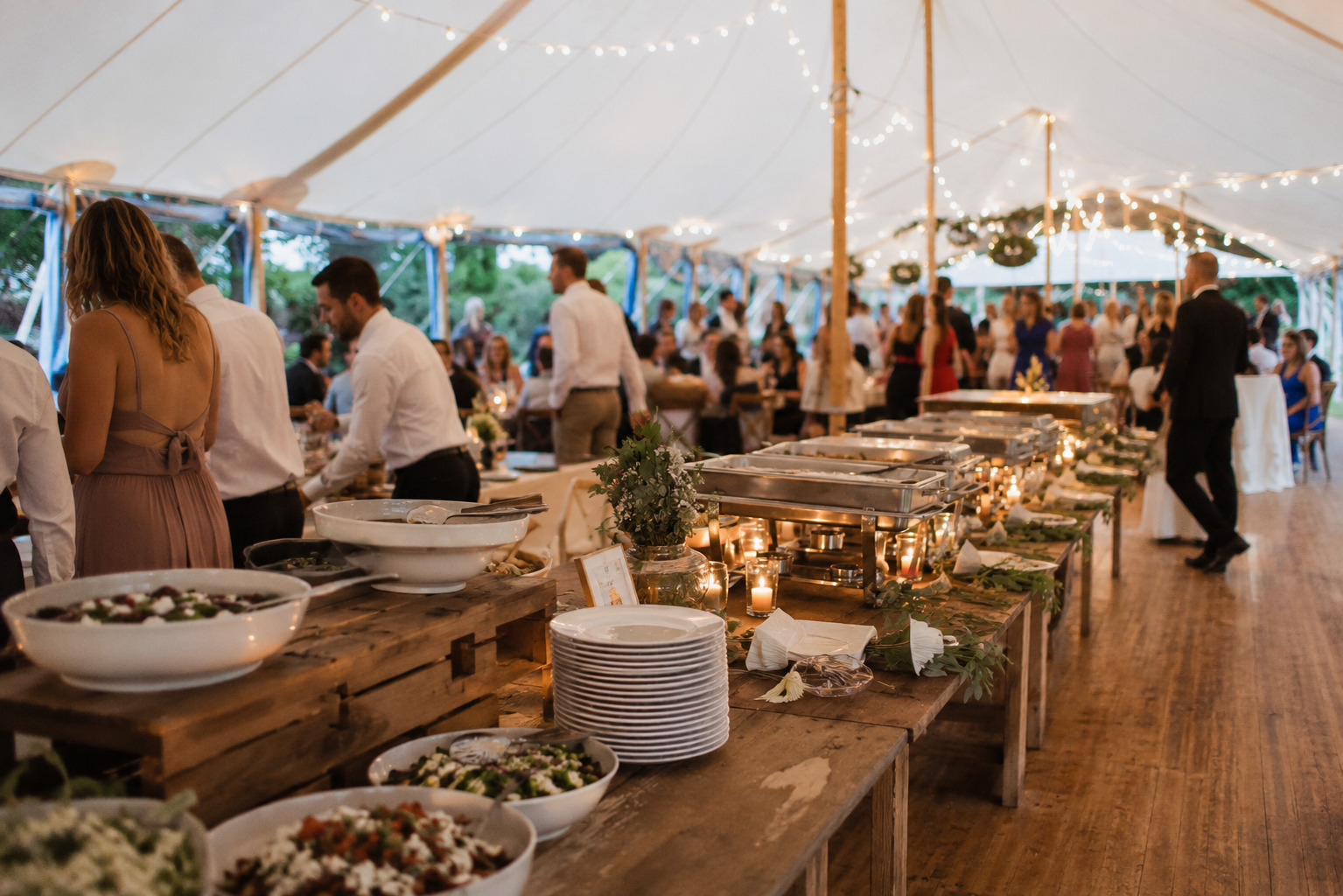 Stilvoll gedeckte Tafel und Catering-Setup in einem eleganten Hochzeitszelt